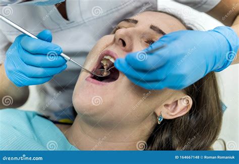 Dentista revisando la boca de un paciente