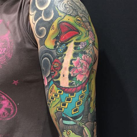 Brazo tatuado con samurái y olas al estilo irezumi