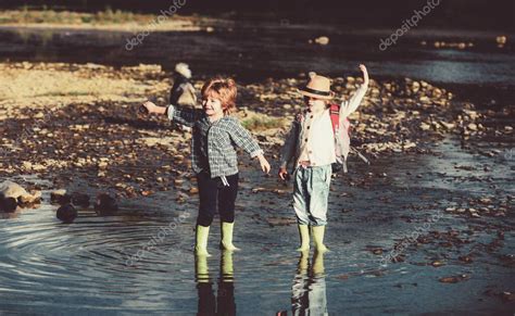 Dos niños lanzando piedras en un río