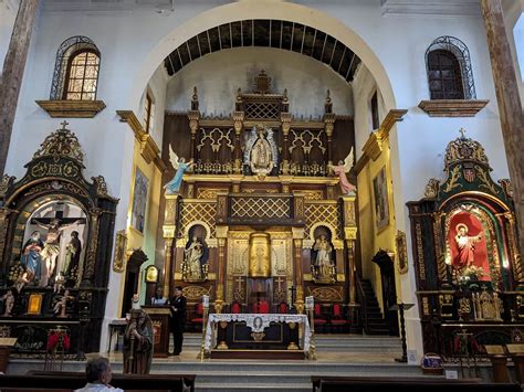 Interior de una iglesia católica con un féretro cubierto con un paño blanco
