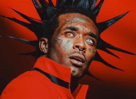 Lil Uzi Vert en concierto con traje rojo y detalles de pentagrama