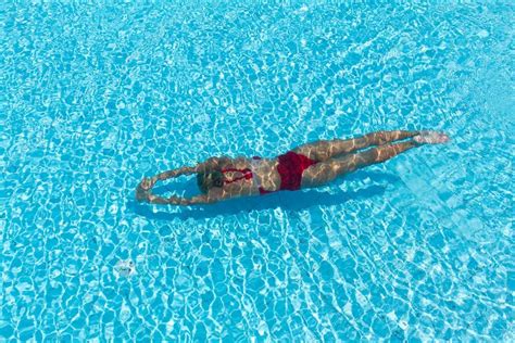 Mujer nadando en piscina con traje de baño deportivo