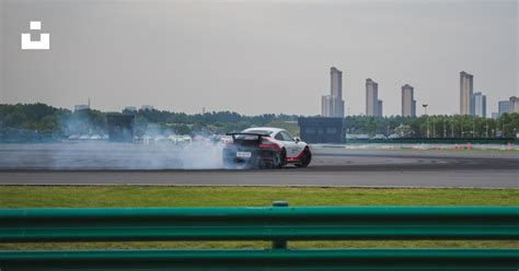 Imagen de un coche de carreras modificado derrapando en una ciudad nocturna