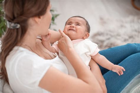 Bebé llorando en brazos de su madre