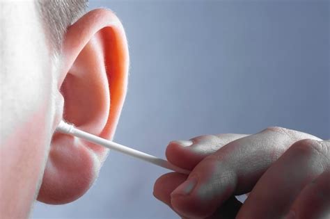 Imagen de un bastoncillo de algodón limpiando las rejillas de los AirPods