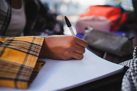 Estudiante escribiendo en un cuaderno con símbolos místicos