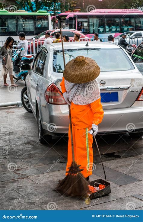 Mujer barriendo la calle con escoba