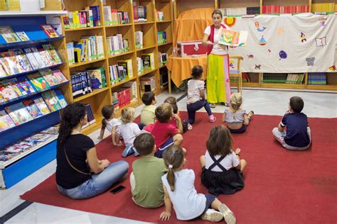 Niños participando en un cuentacuentos en la sección infantil de una biblioteca.