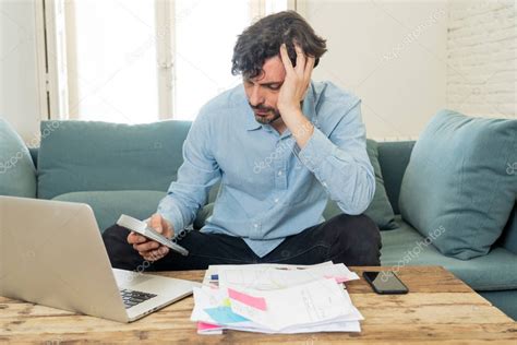 Joven preocupado mirando facturas