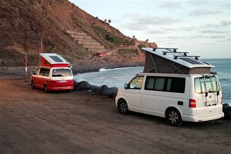 Pareja en furgoneta camperizada viajando hacia la costa