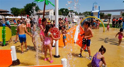Niños jugando en un parque acuático con chorros de agua