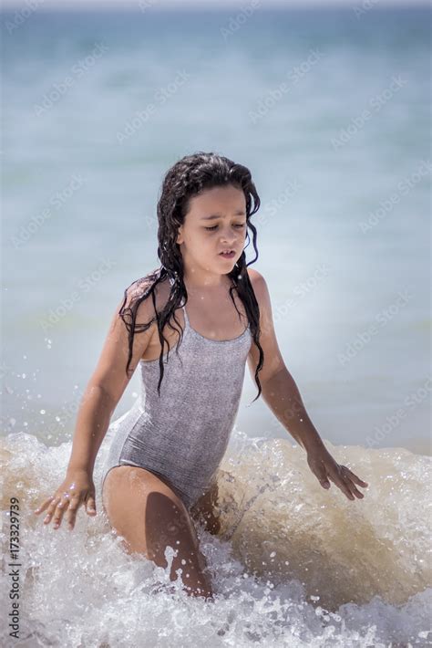 Niña sonriente en la playa con un albornoz
