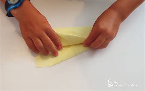 Niño doblando un avión de papel
