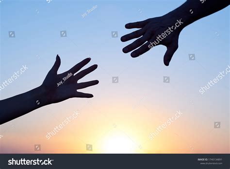 Two hands reaching out, one in shadow