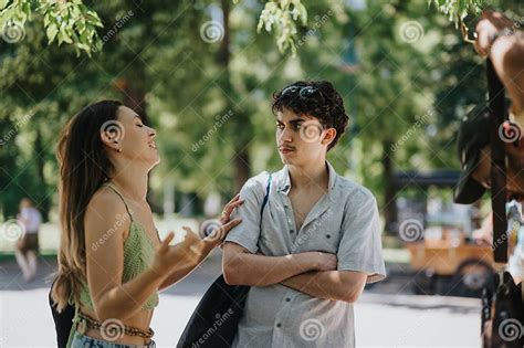 Ilustración de dos amigos conversando en un parque mientras alimentan gatos.