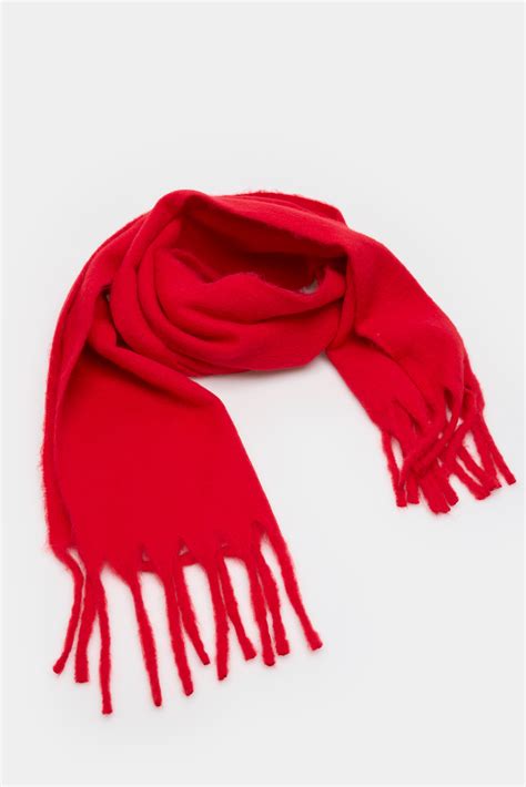 Joven con bufanda roja frente a un árbol gigante