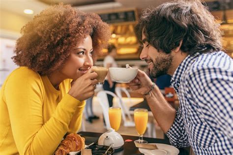 Pareja joven en un café, uno mirando al otro con nostalgia