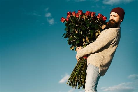 Chico ofreciendo flores a otro chico en un ambiente romántico