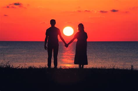Silueta de una pareja observando un amanecer