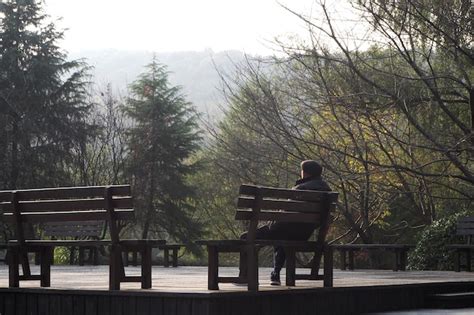 hombre sentado en un banco del parque comiendo curry