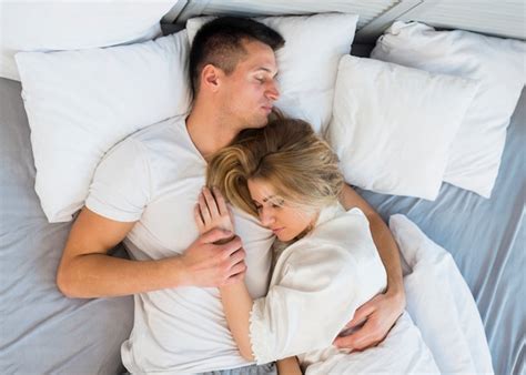 Pareja joven en cama intentando dormir