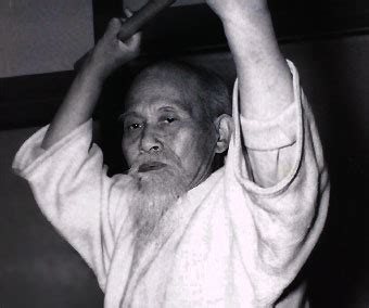 Morihei Ueshiba en Ayabe, 1922, frente a un cartel que indica “Daito-ryu Aiki-jujutsu”