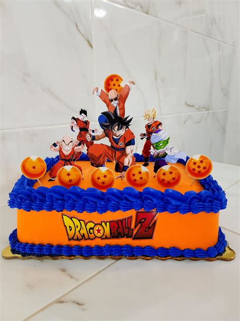 Montaje de tarta temática de Dragon Ball con figuras de Goku y Bulma
