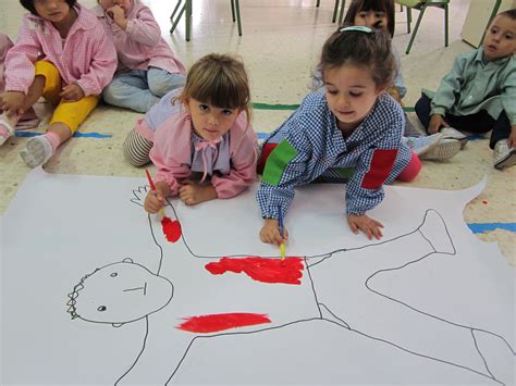 niño dibujando la silueta de otro niño en papel