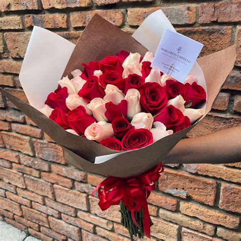 Imagen de un ramo de rosas rojas y una caja de bombones