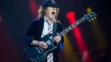 Angus Young tocando la guitarra en un concierto de AC/DC