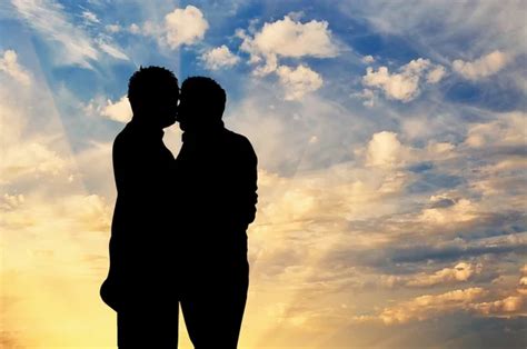 Imagen de dos hombres besándose apasionadamente al atardecer.