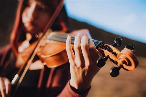Brook tocando el violín en un escenario con luces